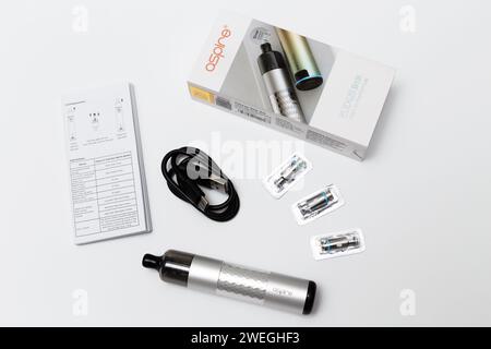 Ukraine, Odesa - 4. Januar 2024: Dampfgerät, Vape Aspire Flexus Stik Pod Kit silberfarbig mit Box, Handbuch, Ladekabel USB Typ-C und Netzspulen auf weißem Hintergrund, Draufsicht. Stockfoto