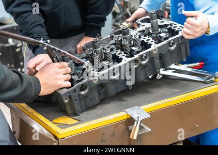 Automechaniker bauen einen zerlegten Automotor in einer Werkstatt zusammen Stockfoto