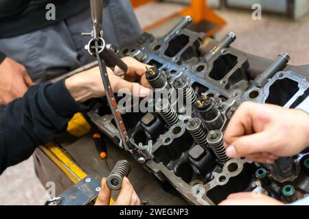 Automechaniker bauen einen zerlegten Automotor in einer Werkstatt zusammen Stockfoto