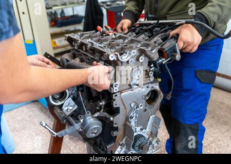 Automechaniker bauen einen zerlegten Automotor in einer Werkstatt zusammen Stockfoto