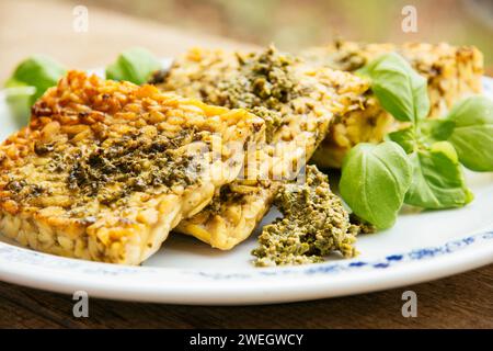 Gebratene Tempeh-Scheiben mit veganem Rucola-Pesto. Stockfoto