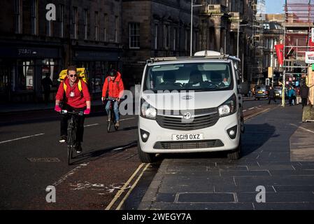 Radfahrer auf der Nicolson Street müssen den Radweg verlassen, weil ein Kleinbus von Arbeitern auf dem Bürgersteig geparkt und den Radweg blockiert hat. Stockfoto