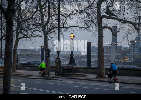 Am frühen Morgen pendeln Radfahrer in die Stadt entlang des Radweges am Victoria Embankment in London, 24. Januar 2024 mit Blackfriars Bridge Hintergrund Stockfoto