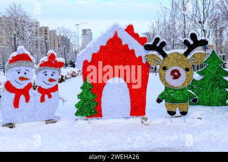 Im Winter stehen festliche Spielzeuge auf der Straße der Stadt. Lustige Häuser, Schneemänner und Hirsche. Dnipro City Stockfoto