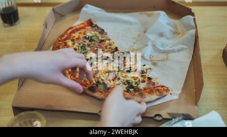 Die Schüler nehmen ein Stück Pizza in der Cafeteria. Stockfoto