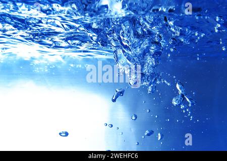 Viele blaue Luftblasen unter der Wasseroberfläche im Aquarium, schäumendes Wasser, Nahaufnahme Stockfoto