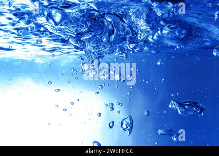 Viele blaue Luftblasen unter der Wasseroberfläche im Aquarium, schäumendes Wasser, Nahaufnahme Stockfoto