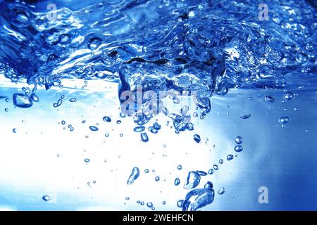 Viele blaue Luftblasen unter der Wasseroberfläche im Aquarium, schäumendes Wasser, Nahaufnahme Stockfoto