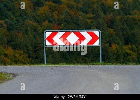 Abzweigung in der Straße in Deutschland zeigt ein Schild die möglichen Richtungen rechts und links, symbolisiert einen Scheideweg, der eine Entscheidung trifft Stockfoto