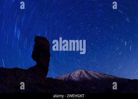 Der Roque Cinchado bei Nacht mit kreisenden Sternen am klaren Nachthimmel und dem Gipfel des Pico de Teide, Teneriffa, Kanarischen Inseln, Spanien Stockfoto