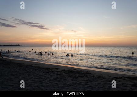 Wunderschöne Strandlandschaft in der Abenddämmerung mit touristischer Silhouette ins Meer Stockfoto