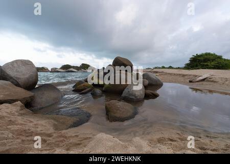 Kleiner felsiger Hügel mitten in einer Mündung am Strand von arrecife in den tayrona Nationalpark Stockfoto