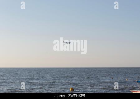 Ein Avianca-Jet-Flugzeug, das über die karibik fliegt und auf Santa marta landet, vom Strand aus gesehen Stockfoto