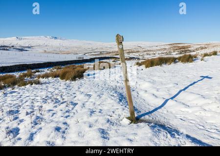 Ein Wegweiser in den Yorkshire Dales in England an einem wunderschönen winterlichen Tag mit viel Schnee auf dem Boden und klarem blauem Himmel. Auf den drei Gipfeln. Stockfoto