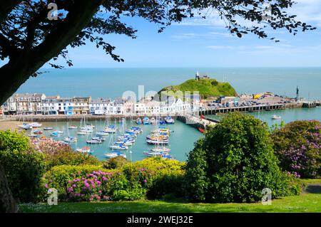 Sonniger Meerblick auf Ilfracombe mit Booten und Yachten im Hafen und Gebäuden entlang des Kais unter der St. Nicholas Chapel, North Devon Coast, England, Großbritannien Stockfoto