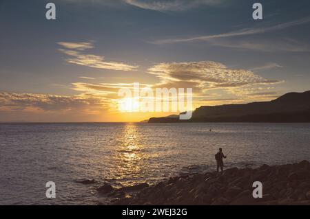 Man fischt bei Sonnenuntergang, Kimmeridge Bay, Isle of Purbeck, Jurassic Coast World Heritage Site, Dorset, England, Großbritannien Stockfoto