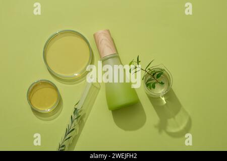 Mockup-Szene für Werbemittel mit natürlichem Extrakt. Glasflasche unbeschriftet dekoriert mit Laborglas mit Essence und grünem Blatt auf gr Stockfoto