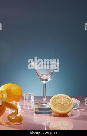 Glasbecher mit eis und frischen Zitronen auf dunkelblauem Hintergrund. Szene für die Werbung für Getränkeprodukte mit frischem Zitronengeschmack für eine Erfrischung Stockfoto