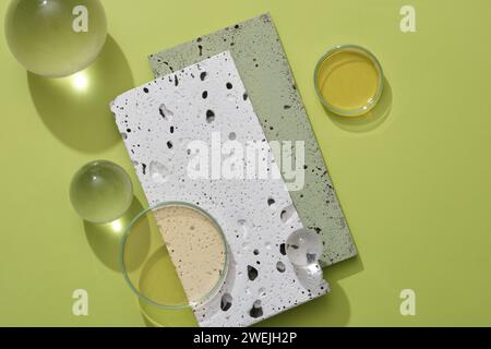 Blick von oben auf weiße und graue Ziegelsteine mit einigen Glaskugeln und Petrischale mit gelber Flüssigkeit. Leeres Feld für die Anzeige von Kosmetikprodukten. Erw Stockfoto