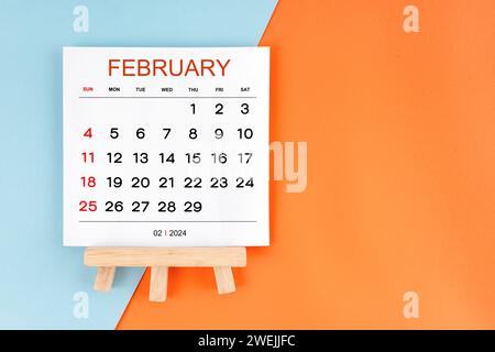 Kalenderseite für den 2024. Februar auf blauem und orangefarbenem Hintergrund. Stockfoto