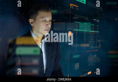 Geschäftsmann vor einem modernen digitalen virtuellen Touchscreen, der das Anlagerisikomanagement und die ROI-Analyse oder die geschäftliche Leistung analysiert Stockfoto