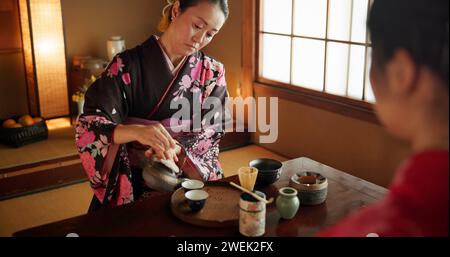 Japaner, Frauen und Matcha zur Teezeremonie im Chashitsu-Zimmer mit Kimono-Kleid und traditionellem Brauch. Person, temae und Vintage-Outfit für Stockfoto