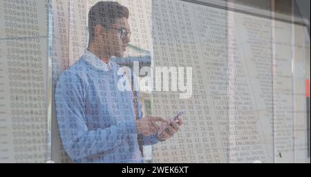 Bild der Zahlenänderung und Datenverarbeitung auf Computerbildschirmen über Mann mit Smartphone Stockfoto