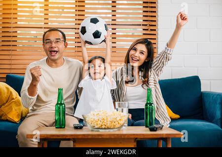 Eine glückliche Familie genießt den Nervenkitzel eines Fußballspiels zu Hause Stockfoto