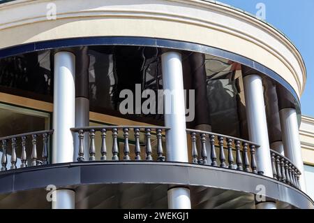 Fragment der Fassade des Gebäudes mit Säulen und Geländern. Balkon mit Balustrade Stockfoto