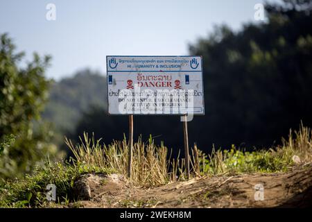 Am 25. Oktober 2023 steht in der Nähe von Muang Mai, Laos, neben einem Reisfeld, das mit einer nicht explodierten Verordnung (UXO) übersät ist, die nach dem Bombenangriff der Vereinigten Staaten während des Vietnamkriegs im Boden begraben bleibt. Die Räumung des Standorts erfolgt durch Feldbetreiber oder Minenräumer, die für die internationale Nichtregierungsorganisation Humanity and Inclusion arbeiten. Stockfoto