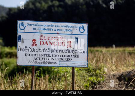 Am 25. Oktober 2023 steht in der Nähe von Muang Mai, Laos, neben einem Reisfeld, das mit einer nicht explodierten Verordnung (UXO) übersät ist, die nach dem Bombenangriff der Vereinigten Staaten während des Vietnamkriegs im Boden begraben bleibt. Die Räumung des Standorts erfolgt durch Feldbetreiber oder Minenräumer, die für die internationale Nichtregierungsorganisation Humanity and Inclusion arbeiten. Stockfoto