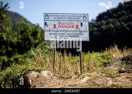 Am 25. Oktober 2023 steht in der Nähe von Muang Mai, Laos, neben einem Reisfeld, das mit einer nicht explodierten Verordnung (UXO) übersät ist, die nach dem Bombenangriff der Vereinigten Staaten während des Vietnamkriegs im Boden begraben bleibt. Die Räumung des Standorts erfolgt durch Feldbetreiber oder Minenräumer, die für die internationale Nichtregierungsorganisation Humanity and Inclusion arbeiten. Stockfoto