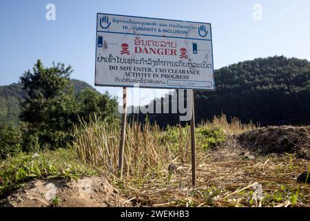 Am 25. Oktober 2023 steht in der Nähe von Muang Mai, Laos, neben einem Reisfeld, das mit einer nicht explodierten Verordnung (UXO) übersät ist, die nach dem Bombenangriff der Vereinigten Staaten während des Vietnamkriegs im Boden begraben bleibt. Die Räumung des Standorts erfolgt durch Feldbetreiber oder Minenräumer, die für die internationale Nichtregierungsorganisation Humanity and Inclusion arbeiten. Stockfoto