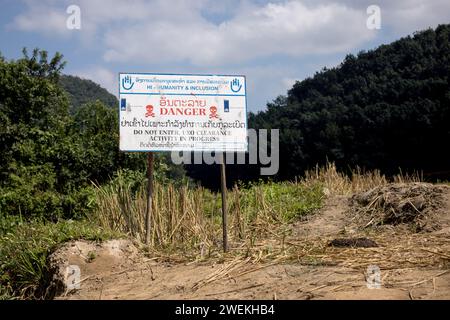 Am 25. Oktober 2023 steht in der Nähe von Muang Mai, Laos, neben einem Reisfeld, das mit einer nicht explodierten Verordnung (UXO) übersät ist, die nach dem Bombenangriff der Vereinigten Staaten während des Vietnamkriegs im Boden begraben bleibt. Die Räumung des Standorts erfolgt durch Feldbetreiber oder Minenräumer, die für die internationale Nichtregierungsorganisation Humanity and Inclusion arbeiten. Stockfoto