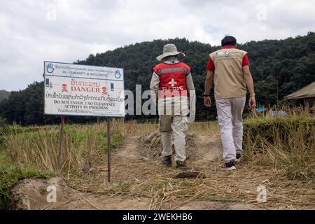 Am 25. Oktober 2023 steht in der Nähe von Muang Mai, Laos, neben einem Reisfeld mit unexplodierten Verordnungen (UXO), die nach dem Bombenangriff der Vereinigten Staaten während des Vietnamkriegs im Boden begraben bleiben ÔDangerÕ. Die Räumung des Standorts erfolgt durch Feldbetreiber oder Minenräumer, die für die internationale Nichtregierungsorganisation Humanity and Inclusion arbeiten. Stockfoto