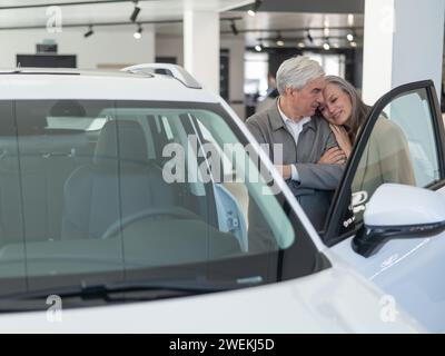 Ein älteres kaukasisches Paar wählt ein neues Auto in einem Autohändler. Stockfoto