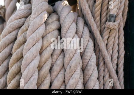 Nahaufnahme mit der komplexen Textur und dem robusten Flechtwerk dicker Seeseile, die ein langjähriges maritimes Erbe widerspiegeln. Stockfoto