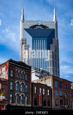 Das ikonische AT&T Building, das in der Gegend als Batman Building bekannt ist, steht hoch vor einem klaren blauen Himmel und überschattet die klassischen Backsteinfassaden von Nashv Stockfoto