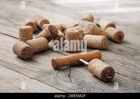 Weinkorken und Korkenzieher auf alten hölzernen, unbemalten Tisch. Stockfoto