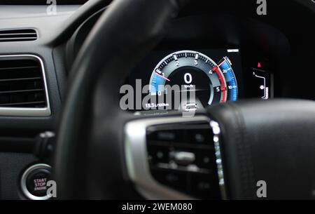 Digitaler Drehzahlmesser mit farbiger Hintergrundbeleuchtung auf der Mitteltafel eines modernen Autos Stockfoto