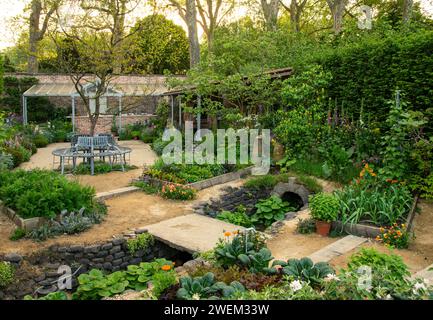 Dekorative und essbare Pflanzen in einem ummauerten Garten im Savills Garden, entworfen von Mark Gregory. Stockfoto