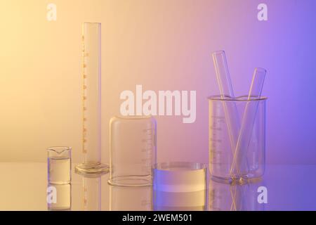 Laborthema mit Laborglas – Reagenzgläser, Becher und transparentes leeres Podium auf Gradientenhintergrund. Leerfläche für Werbung. Wissenschaftslabor Stockfoto