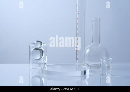 Ein leeres transparentes Podium, Glaskugeln und Laborglas auf weißem Hintergrund. Minimaler Hintergrund mit Kopierraum für Kosmetik und Produkte Stockfoto