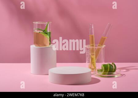Auf der Bühne werden Kosmetikartikel auf dem runden Podium und Laborausrüstung mit gelber Flüssigkeit und Peel Limes auf rosafarbenem Hintergrund gezeigt. Minimales Konzept. Stockfoto
