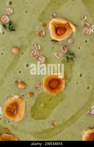 Brokkoli-Creme-Suppe mit Nüssen und Kräutern dekoriert Stockfoto