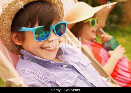 Jungen und Mädchen, die mit Stroh Hut und Sonnenbrille Lächeln Stockfoto