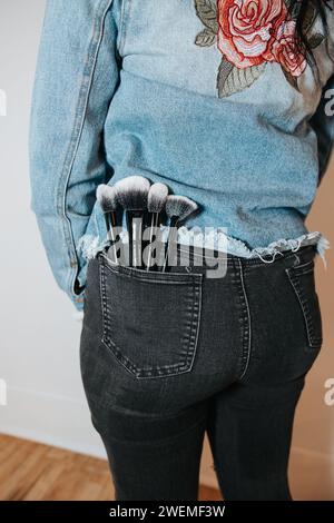 Schminkbürsten in der Gesäßtasche stylischer Jeans Stockfoto