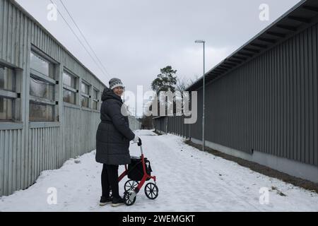 Frau im Ruhestand, die glücklich mit ihrem Rollator im Schnee läuft Stockfoto