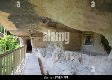 Pfad mit Geländer führt zu einer Höhlenwohnung umgeben von Vegetation, Aladja Kloster, Aladja Kloster, Aladzha Kloster, mittelalterliches Felsenkloster Stockfoto