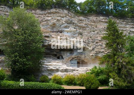 Blick auf Höhlenwohnungen in einer großen Felswände umgeben von Bäumen und Grün, Aladja Kloster auf 2 Ebenen, Aladja Kloster, Aladzha Kloster Stockfoto